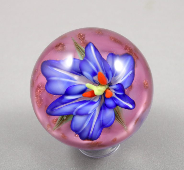 Marble with a blue flower on a pink background