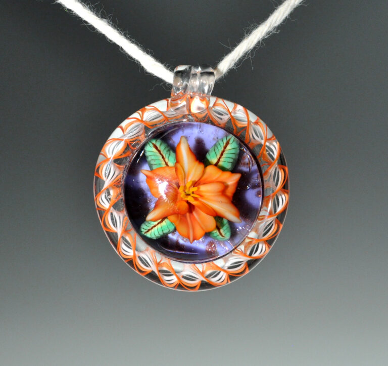 Pendant with an orange flower on dark violet, framed by an orange and white twisted rim
