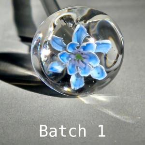 Light blue star flower with lilac stamens, a test bloom of Blue Star 3-D murrine cane batch 1 in a clear borosilicate sphere