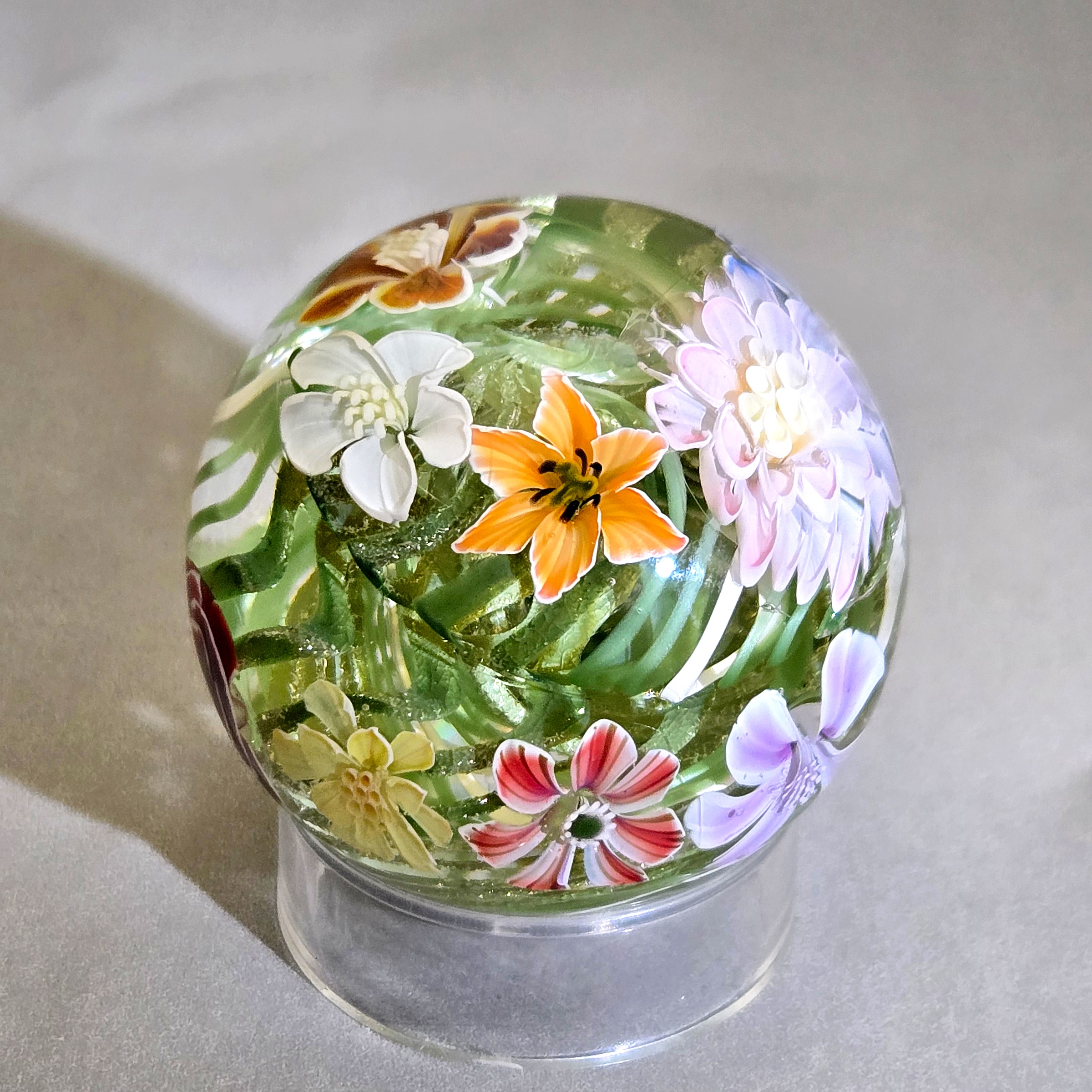 Flower vortex marble, 41mm, with 17 three-dimensional flowers around a green and white core, view 1