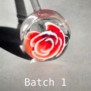 Test bloom of Red Rose 3-D murrine cane batch 1: white-edged red petals spiral around a deep red heart, in a clear borosilicate sphere