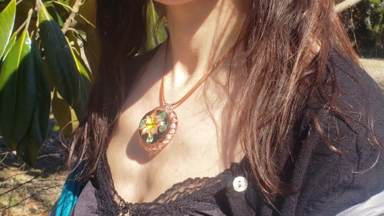 Flower murrine pendant worn on a leather cord (video)