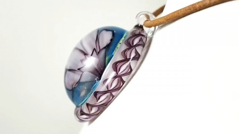 Pendant with a white flower and a purple twisted rim, on a leather cord (video)