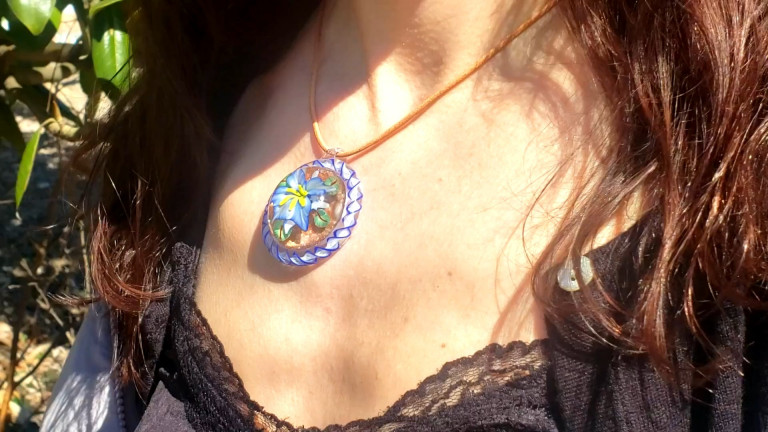 Pendant with a blue flower worn on a leather cord (video)