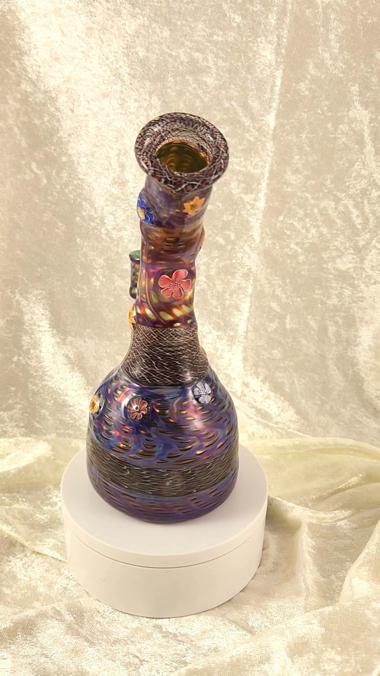 Purple and gold glass water pipe with murrine flowers on a white stand (video)